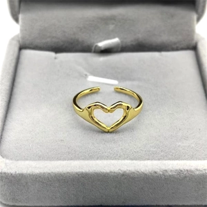 Detail of adjustable gold ring featuring a hollow heart-shaped hands design