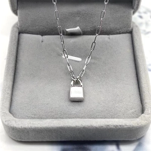 Minimalist S925 sterling silver padlock necklace with paperclip chain on grey velvet