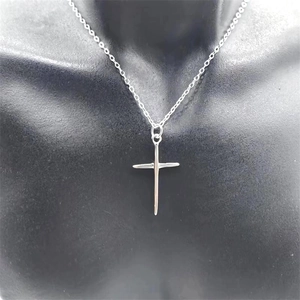 Detailed view of minimalist S925 sterling silver cross pendant on a black mannequin
