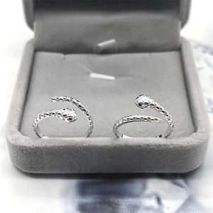 Detailed view of silver snake-shaped rings with diamond-set eyes and scaled texture