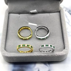 Close-up of gold and silver S925 sterling silver hoop earrings with green and white zircons