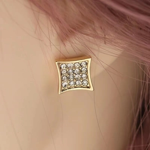 Detailed close-up of a square gold stud earring with 16 sparkling zircon stones on an ear