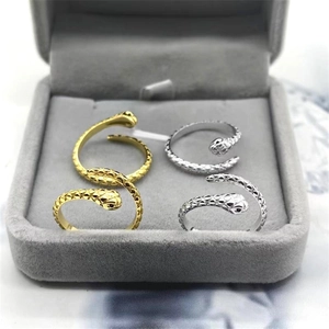 Macro detail of gold and silver snake rings with textured scales in a jewelry box
