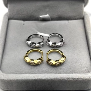 Vue détaillée du poinçon S925 sur des boucles d'oreilles en argent et dorées avec zircon