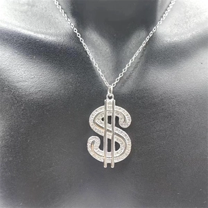 Gros plan du pendentif signe dollar en argent 925 avec zircons blancs sur un collier fin