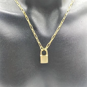 Close-up of a gold padlock pendant on a paperclip chain necklace shown on a black bust