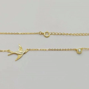 Détail du pendentif hirondelle en argent S925 doré avec un zircon scintillant