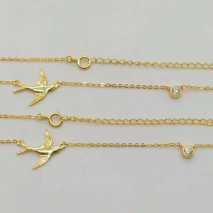 Détail du pendentif hirondelle dorée et breloque en zircon sur une fine chaîne en argent S925
