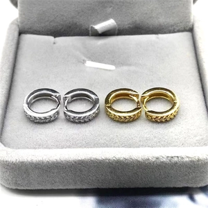 Detailed close-up of gold and silver S925 sterling silver hoop earrings with leaf patterns