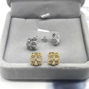 Vue détaillée des boucles d'oreilles carrées en argent et or avec zircons clairs