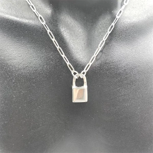 Close-up of minimalist silver padlock pendant on a trendy paperclip chain necklace