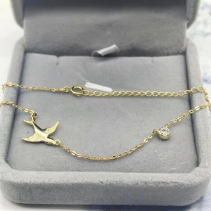 Détail du pendentif hirondelle en argent S925 plaqué or avec zircon sur velours