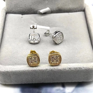 Detailed view of square pavé stud earrings in silver and gold plating on velvet
