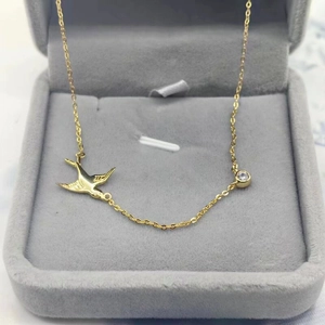 Collier hirondelle en argent S925 plaqué or avec zircon dans un écrin à bijoux gris