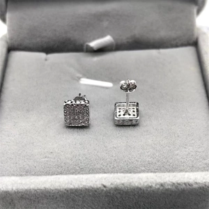 Macro shot of square S925 silver stud earrings with zircon inlay and butterfly back closure