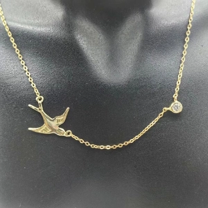 Détail du collier hirondelle en argent plaqué or avec pendentif en zircon sur mannequin