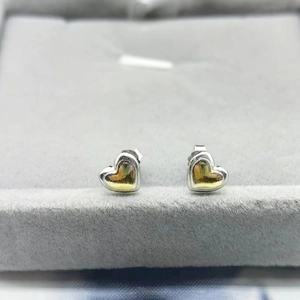 Close-up of S925 sterling silver heart studs with gold mirror finish in a jewelry box