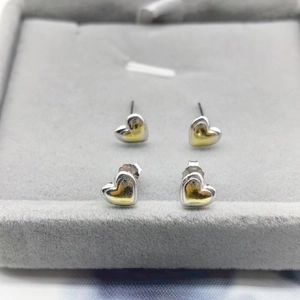 Detail of S925 sterling silver heart earrings with two-tone gold and silver finish