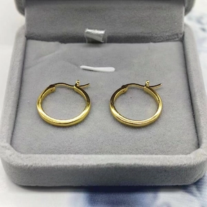 Classic gold round hoop earrings in a gray jewelry box with a minimalist design
