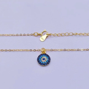 Close-up of S925 sterling silver evil eye pendant with blue zircon stones on gold chain