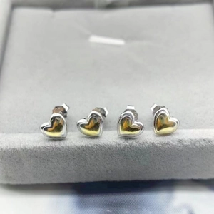 Close-up of four S925 sterling silver heart earrings in silver and gold dual-tone