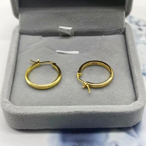 Macro view of gold S925 sterling silver hoop earrings in a gray velvet jewelry box