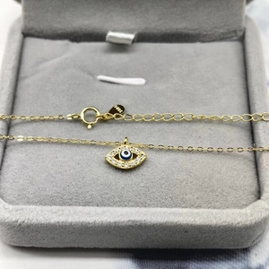 Détail du poinçon S925 sur le collier œil protecteur doré dans son écrin gris
