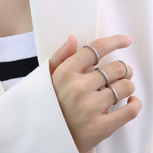 Close-up of minimalist S925 sterling silver rings stacked on a model's finger