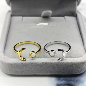 Detail of adjustable silver moon rings with opal stones and zircon accents on velvet