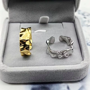 Macro view of gold and silver S925 rings with hammered irregular wave textures
