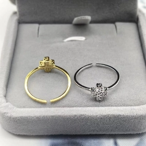 Detail of adjustable S925 silver cross rings with textured finish in gold and silver