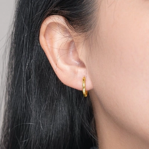 Close-up of a model wearing a polished gold geometric hoop earring for women