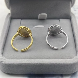 Detail of minimalist adjustable shield rings in gold and silver finish on velvet