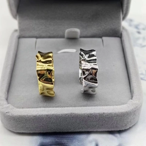 Macro detail of gold and silver crumpled texture rings in a gray velvet jewelry box
