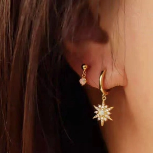 Close-up of golden S925 sterling silver opal star earrings worn on a female model
