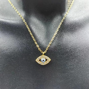 Collier mauvais œil en argent S925 doré présenté sur un buste de mannequin noir