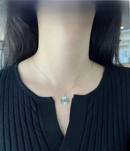 Close-up of S925 sterling silver sunburst disc necklace worn on a female neck