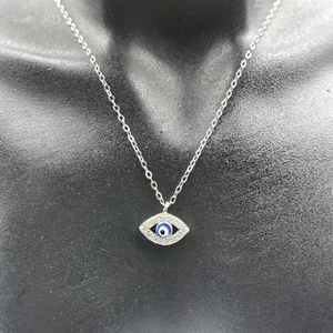 Détail du pendentif œil bleu en argent S925 avec cristaux monté sur un buste noir