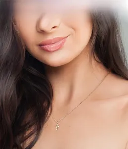 Close-up of S925 silver gold cross pendant necklace with diamonds on woman's collarbone