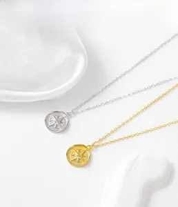 Detailed macro view of S925 sterling silver compass pendants in gold and silver finishes