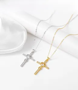 Détail de pendentifs croix en or et argent avec cœur central et pavé de zircons