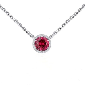 Macro detail of 925 sterling silver necklace with red zircon pendant and vintage engraving