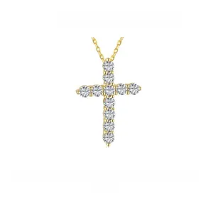 Gros plan sur un pendentif croix en argent doré orné de zircons brillants et fins