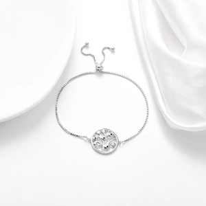 Close-up of adjustable silver tree of life bracelet with blue stones on silk background