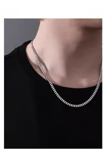 Collier à chaîne cubaine en argent porté par un homme pour un style minimaliste