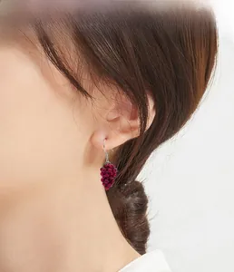 Detailed view of handmade 925 sterling silver grape cluster earrings with red garnets