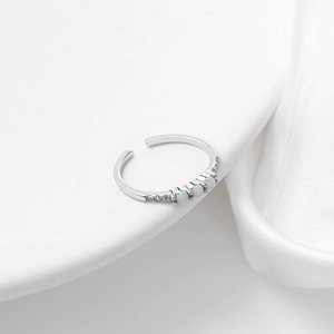 Detail of adjustable silver toe ring featuring three white opals and cubic zirconia accents
