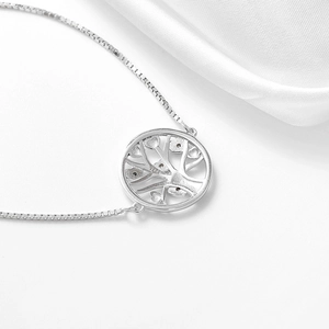 Detailed close-up of S925 sterling silver tree of life bracelet on white silk