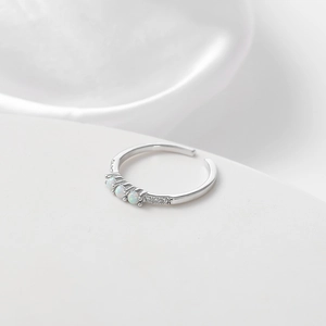 Macro detail of silver adjustable ring with three iridescent opals and side zircons