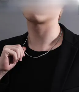 Gros plan d'un collier chaîne gourmette fine en argent s925 sur un mannequin homme
